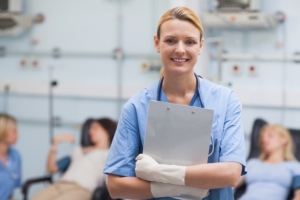 Smiling nurse holding a clipboard in hospital ward
