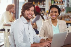 Man and woman using laptop during meeting in cafe technology flexible working