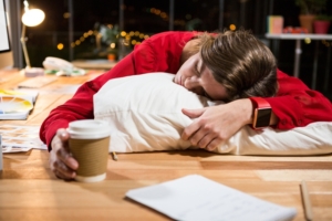 Tired businesswoman sleeping on the desk in the office