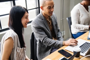 People in an office looking at a laptop