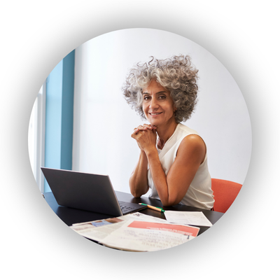 Middle age female professional sitting at desk with laptop