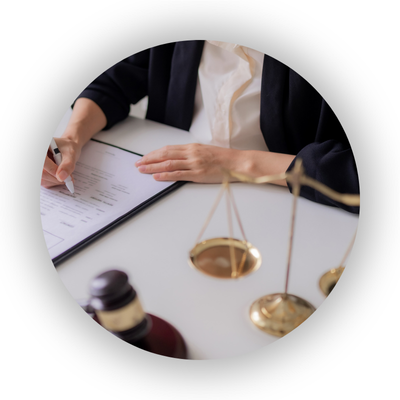 Legal professional reviewing documents, with gavel and scales in foreground