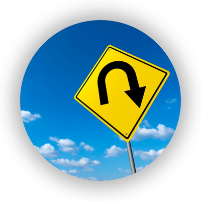 Image of a yellow U-turn sign against a blue sky