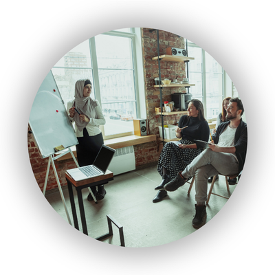 Person teaching adults using whiteboard