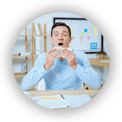 Sneezing male office worker