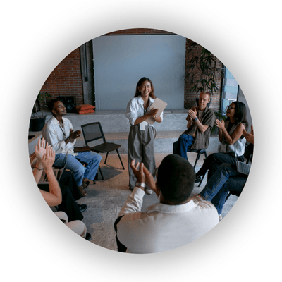 Professionals in a circle applauding centre speaker